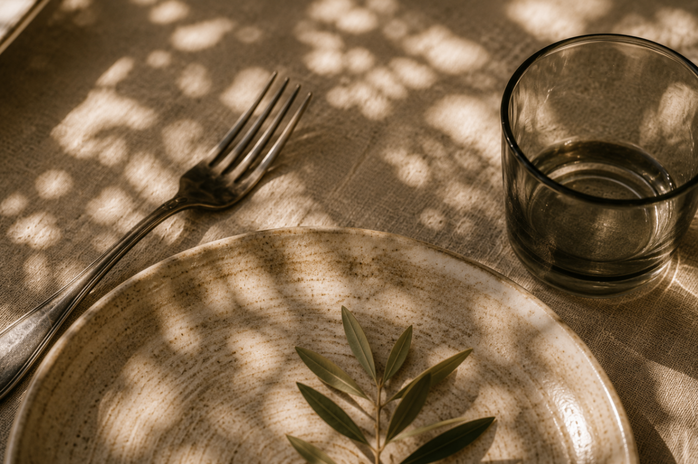 ceramic plate, fork and water glass in dappled afternoon light
